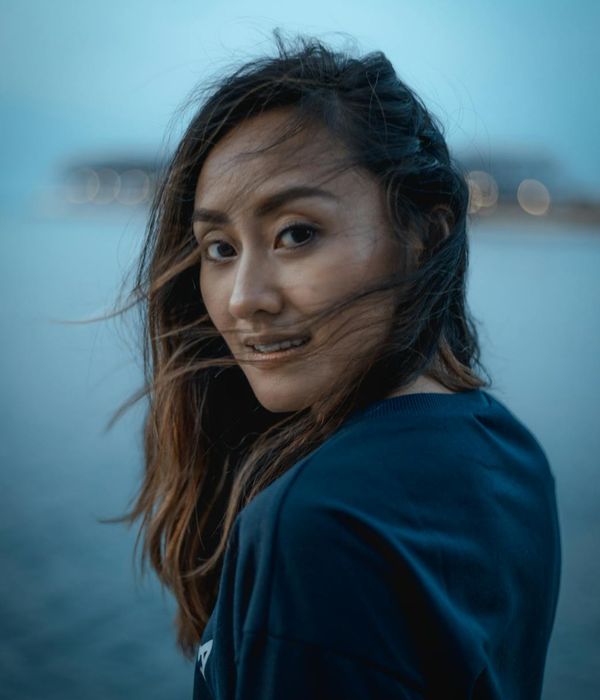 Person stretching gently outdoors, looking refreshed and happy.